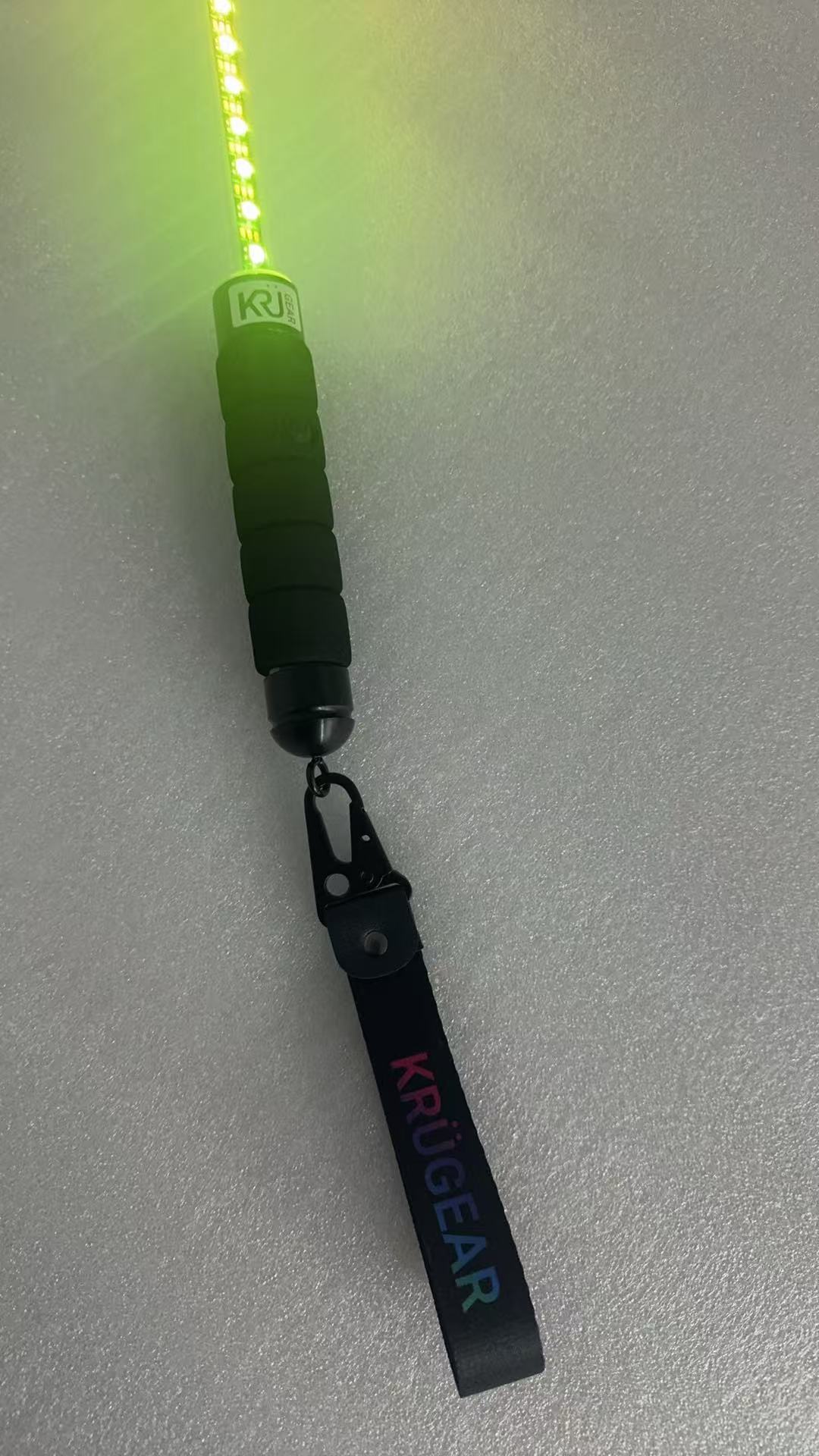 The real KRÜGEAR whip lit green with branded wrist strap